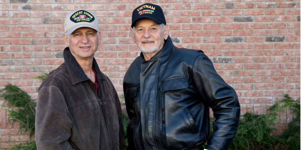 2 veterans posing with their veteran hats